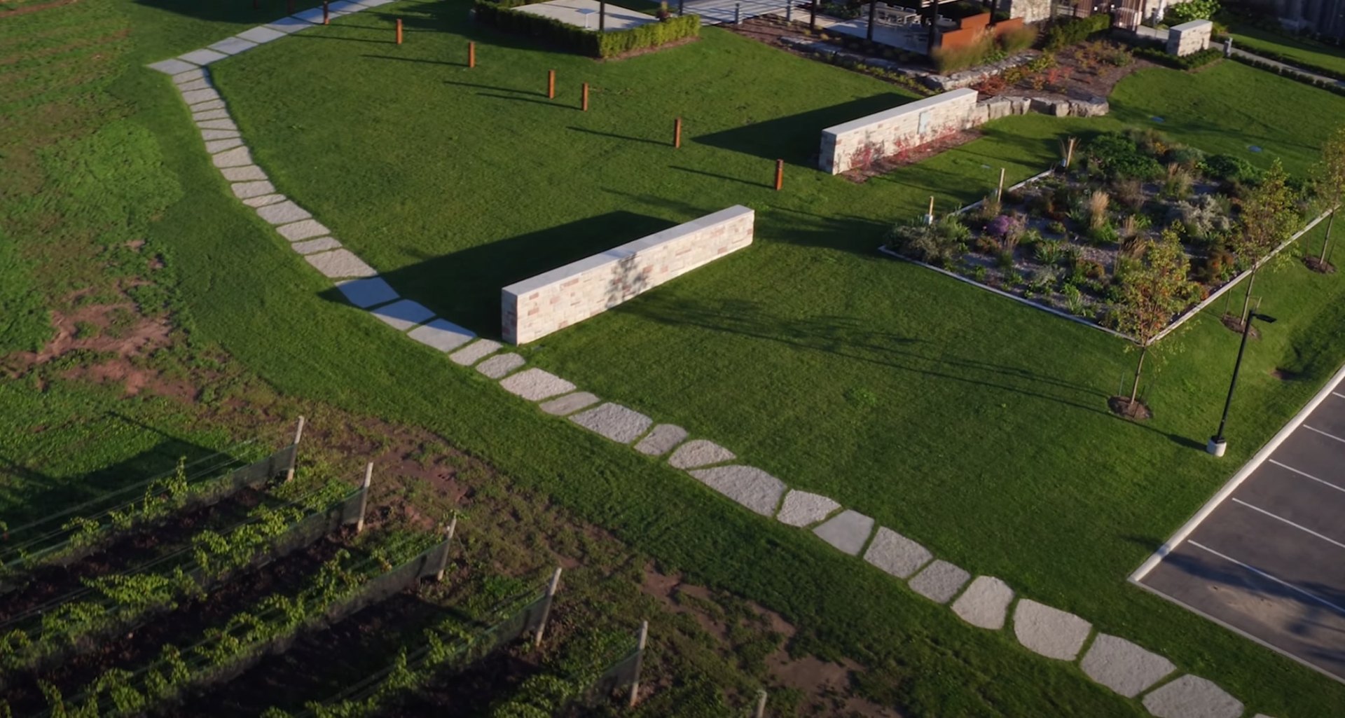 Professional landscape design featuring stone walkways and perfectly maintained grass areas Aerial view of professional landscaping with stone pathways and manicured lawn areas