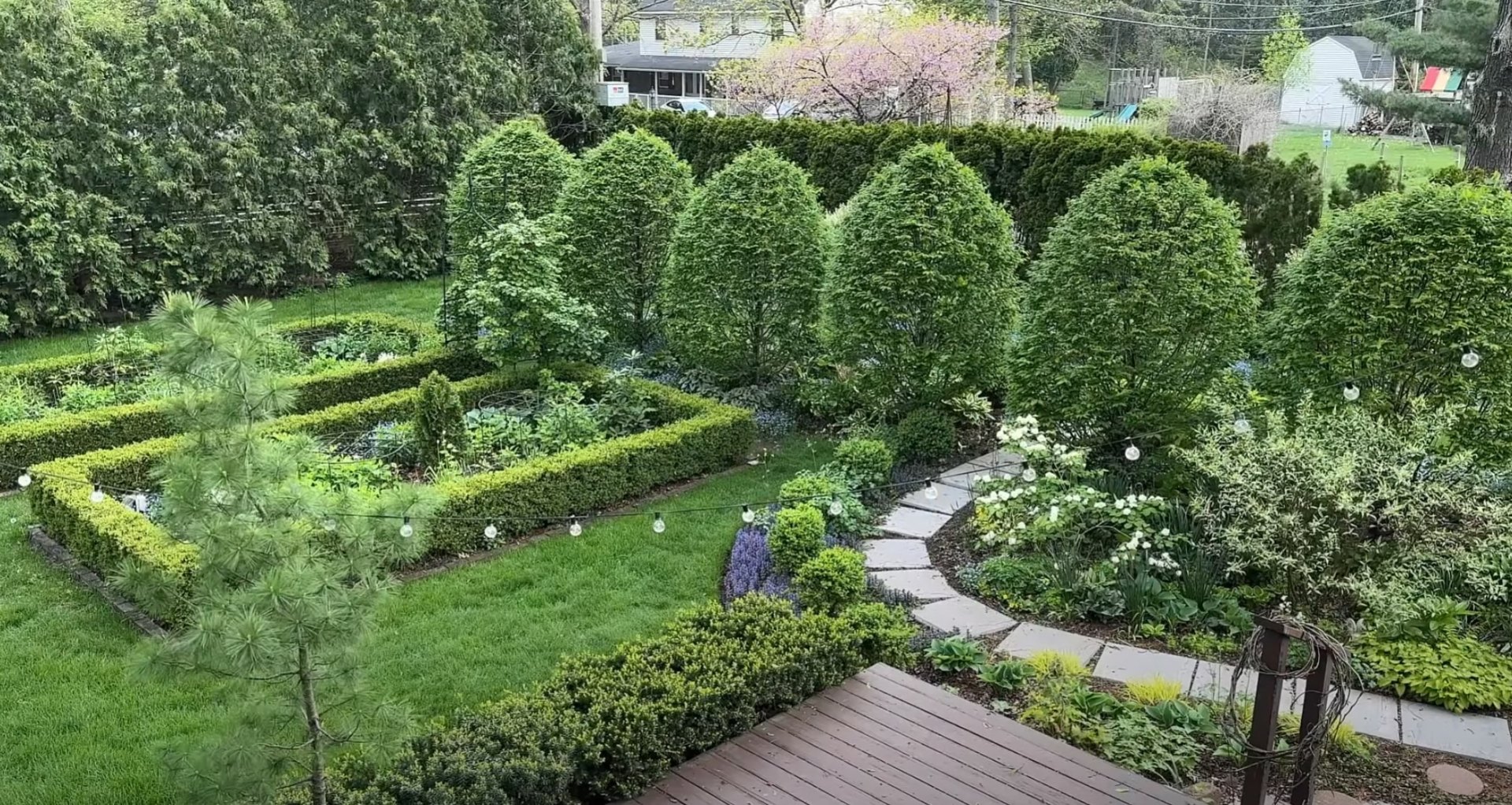 Multi-level garden design with diverse plantings and natural stone features Lush garden landscape with tiered plantings and natural stone elements
